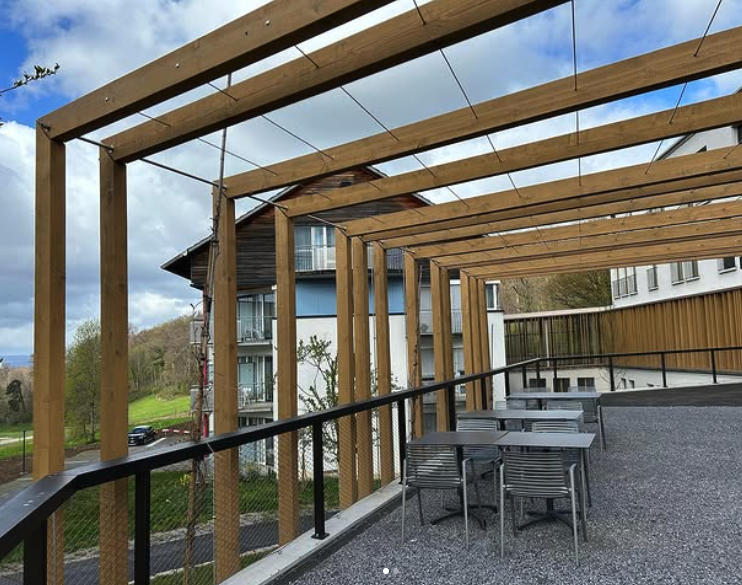 Holzpergola mit Metallgeländer auf Terrasse